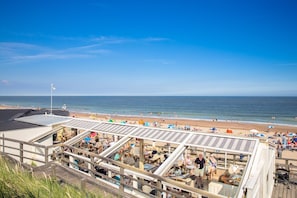 Un restaurant a la vora de la platja amb terrassa exterior amb vistes a l'oceà.
