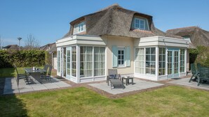 A house with a large patio, a dining area, and a conservatory. - Villa in Domburg near North Sea Beach (Domburg)