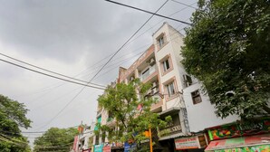 A street with multi-story buildings, some with balconies, and various storefronts including a restaurant. - Hotel Shilo inn  (New Delhi)