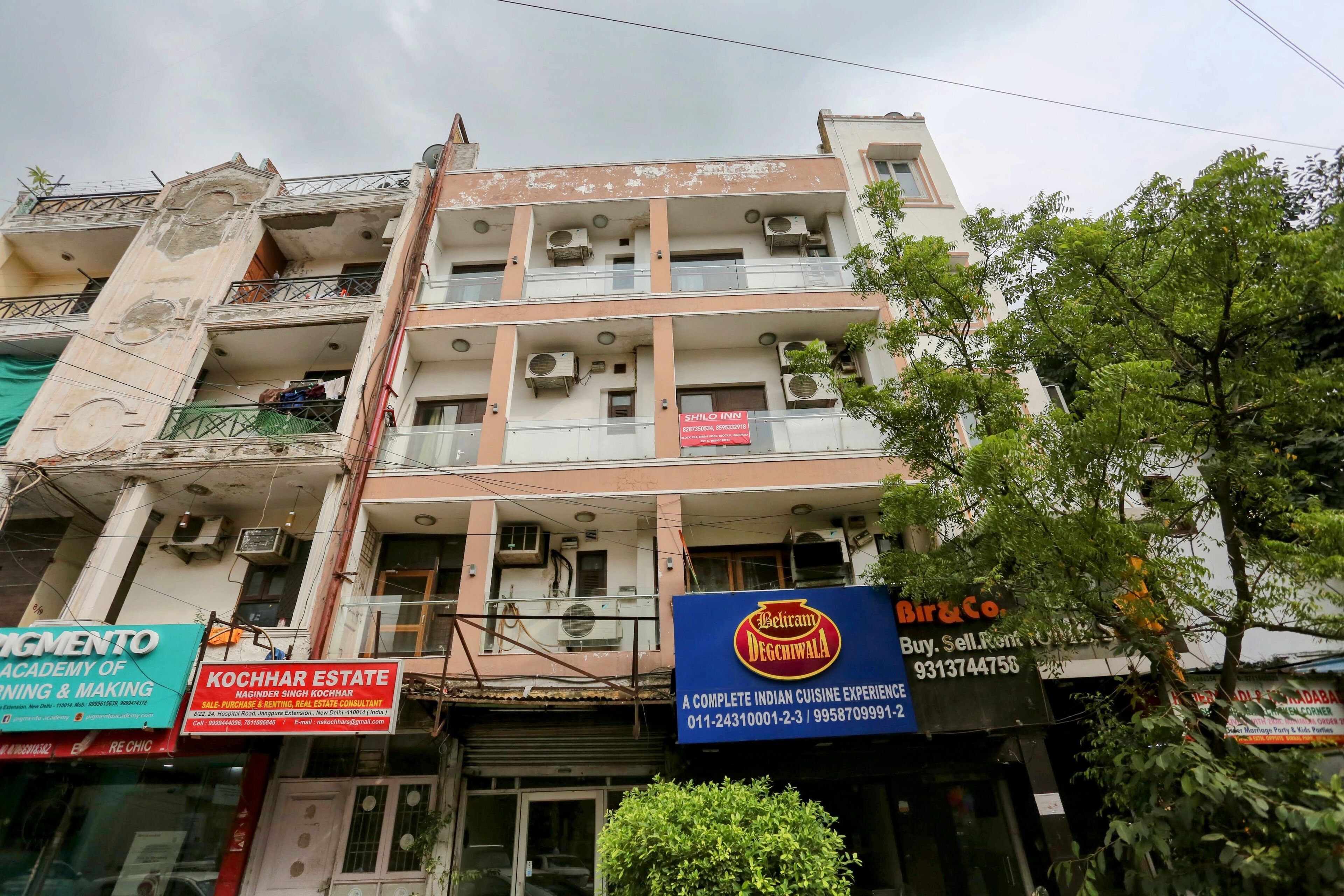 A multi-story building with various businesses including a hotel, an estate agency, and a restaurant.