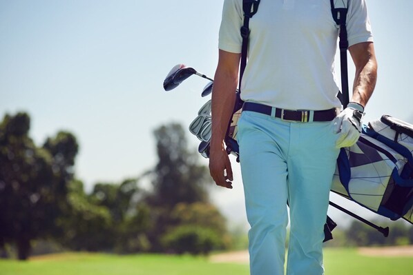 A person carrying a golf bag.