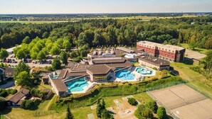Eine Vogelperspektive auf einen Wohnkomplex mit mehreren Gebäuden, einem Schwimmbad und einem Sportplatz.
