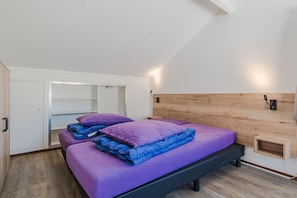 A bedroom with a bed, a wardrobe, and a built-in shelf. - Nature-Set Villa with Microwave Oven (Arcen)