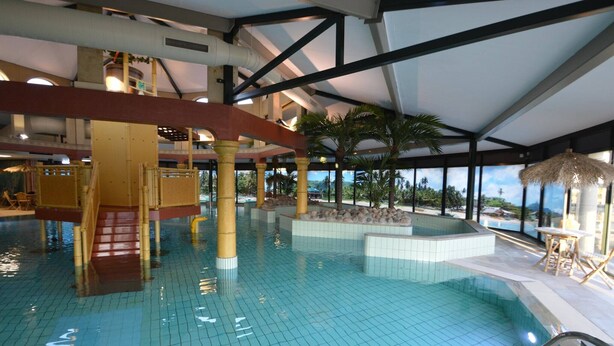 Une piscine intérieure à l’eau cristalline, un grand jacuzzi central et un espace détente avec vue sur l’extérieur.