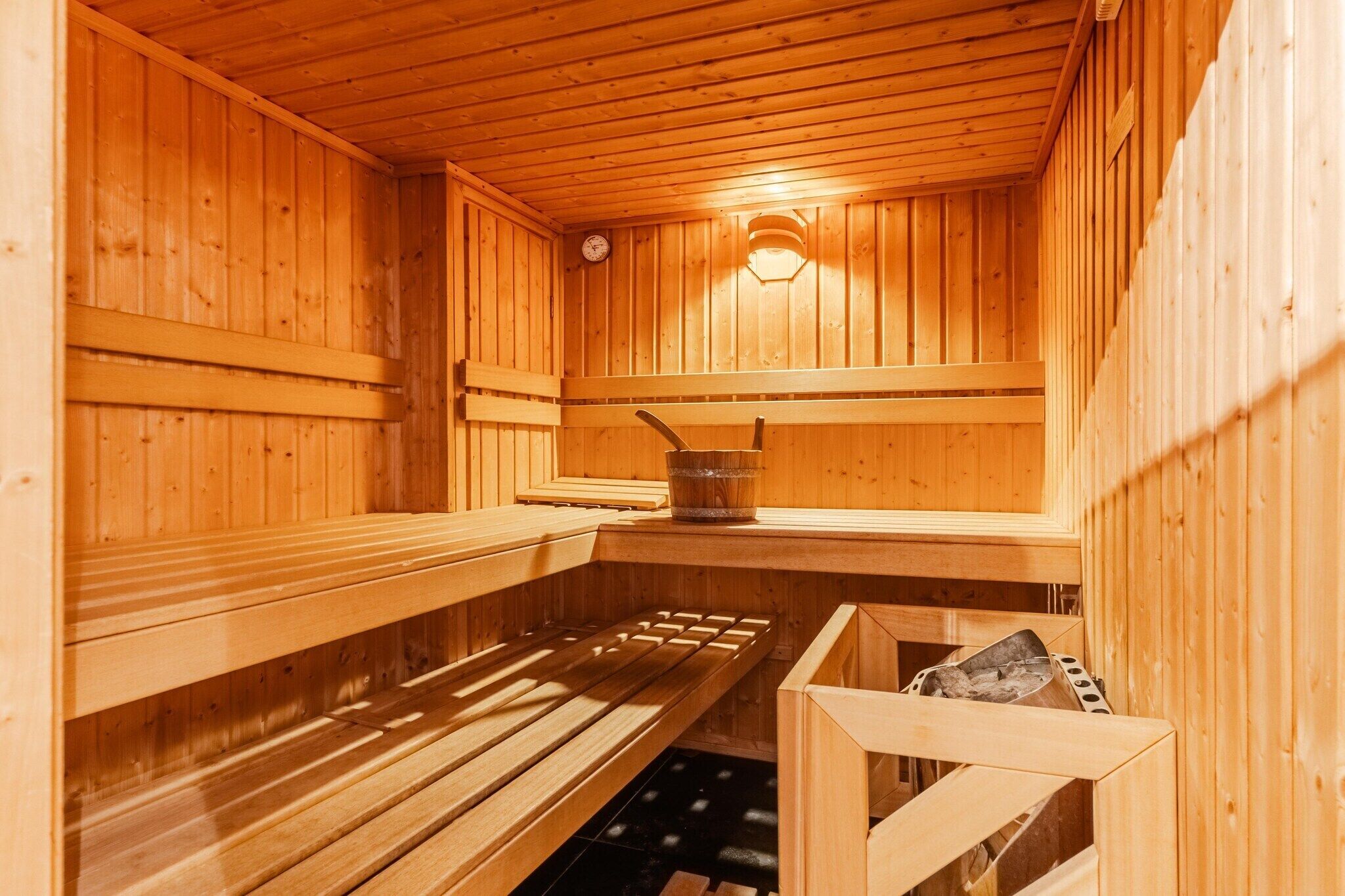 En sauna med træbænke og en stentønde.