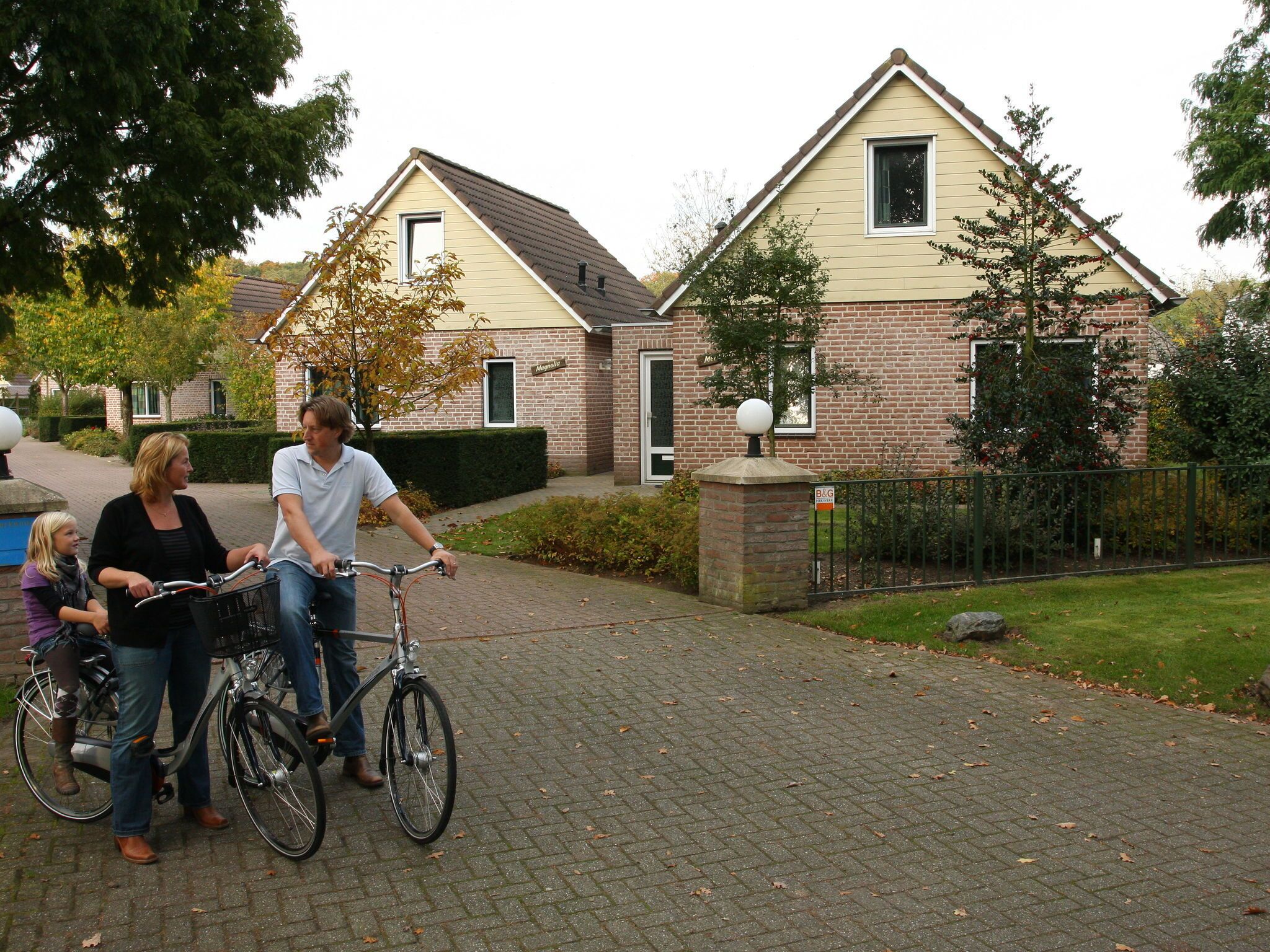 A residential area with houses, a paved driveway, and a gated entrance.