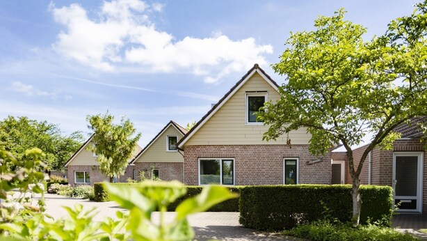 A row of modern houses with brick facades and pitched roofs, surrounded by well-maintained gardens and a paved driveway. - Holiday Home in Netherlands with Private Garden (Plasmolen)