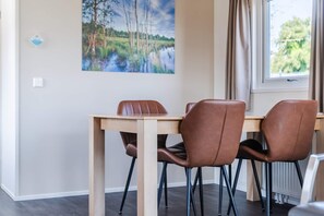 Un coin repas avec une table en bois et quatre chaises marron.