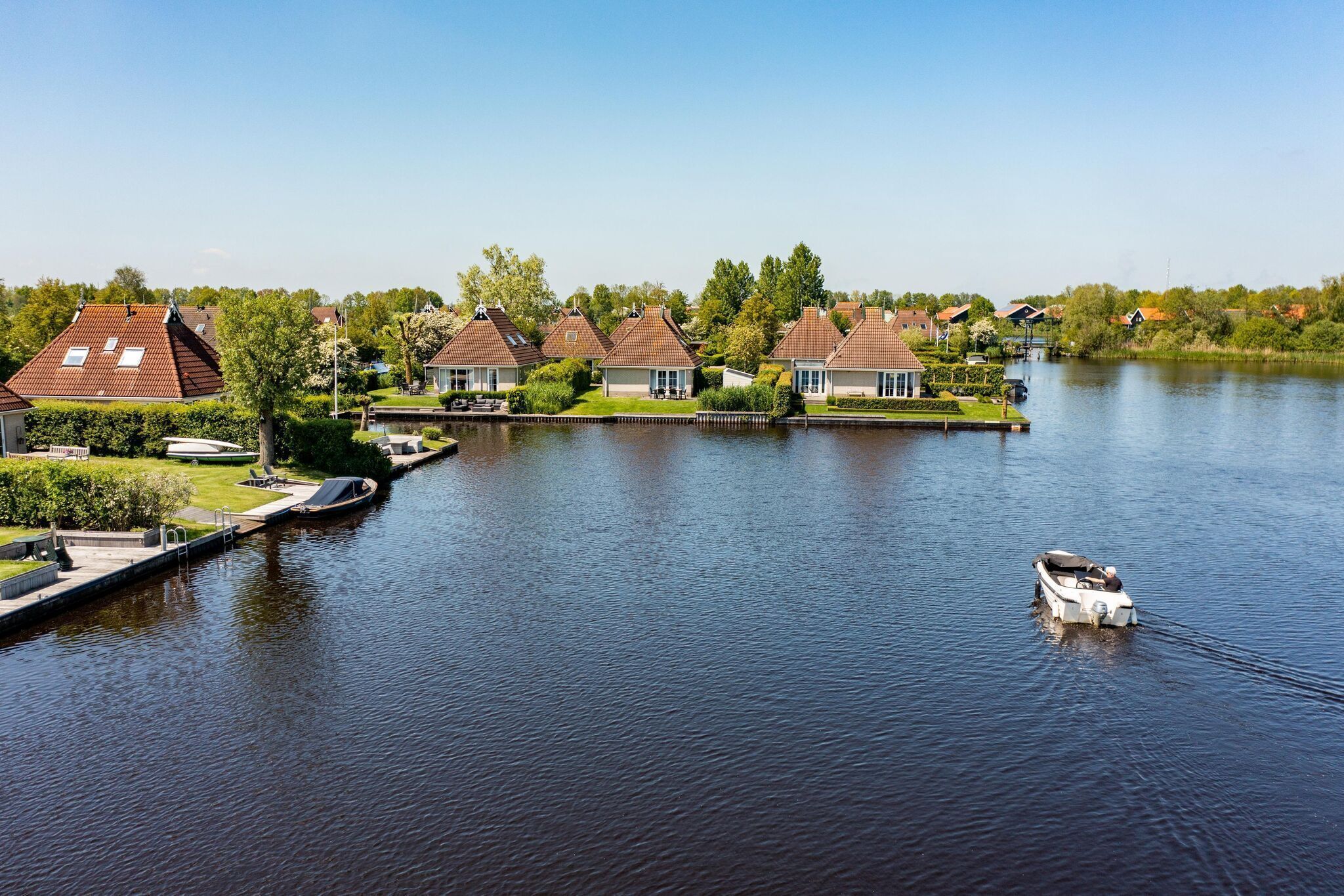 Un quartier résidentiel au bord du lac, avec des maisons, un quai et un bateau.