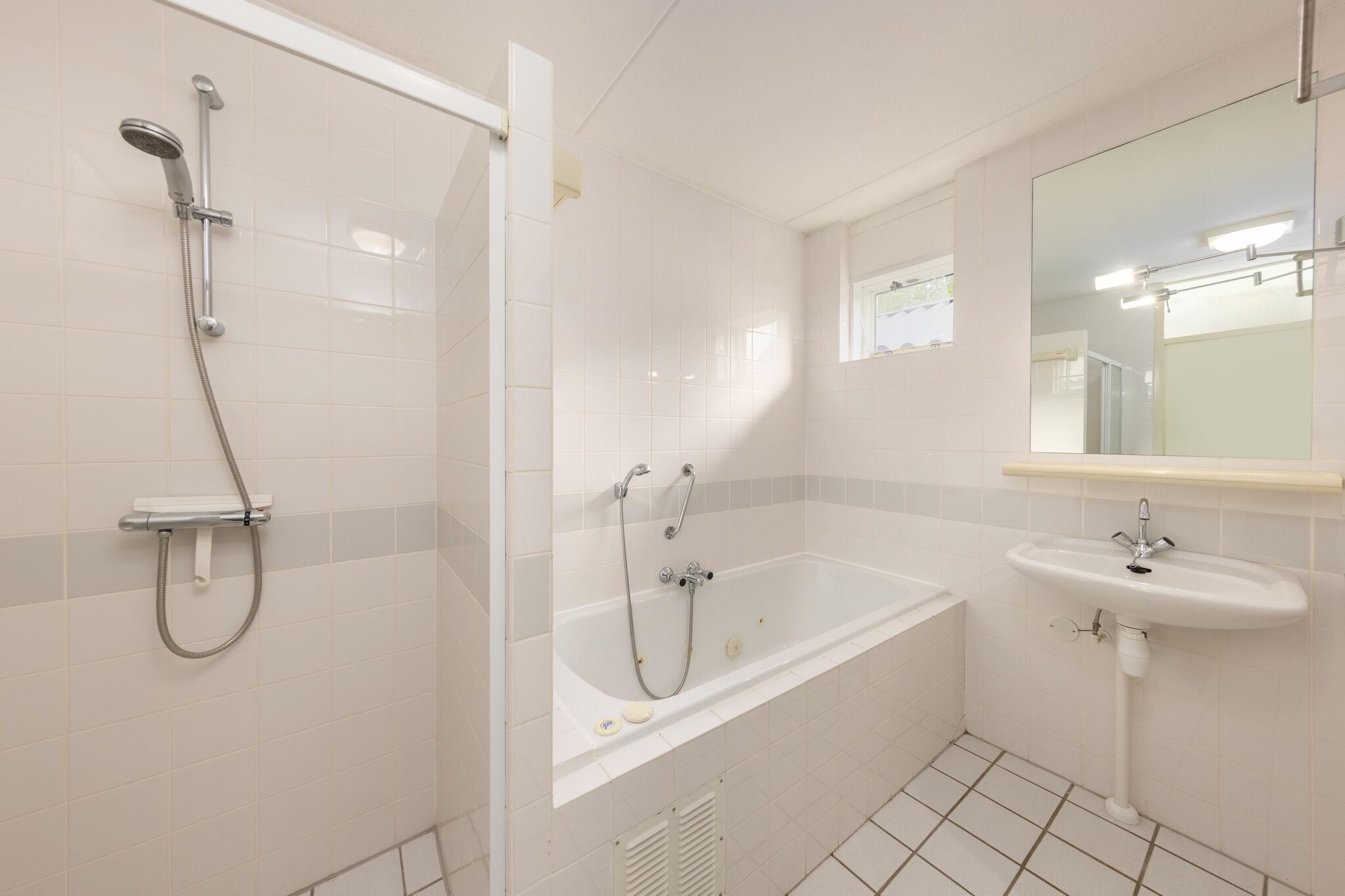 A modern bathroom with a walk-in shower, a freestanding bathtub, and a pedestal sink.