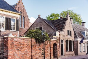 Ein historisches Gebäude mit Ziegelverkleidung, Bogenfenstern und einem traditionellen Dach.