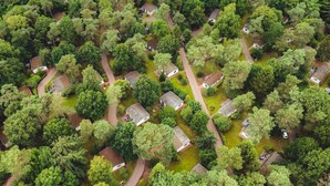 An aerial view of a residential area with houses surrounded by dense trees. - Designer Chalet in the Veluwe (Wissel/Epe)