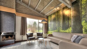 Een moderne woonkamer met een open haard, een bank, twee fauteuils en een salontafel.