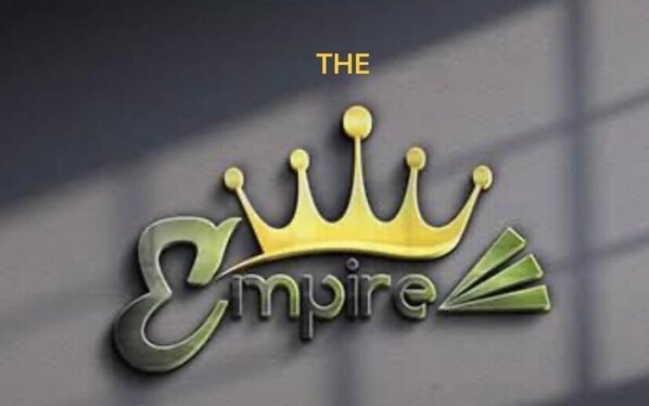 A logo with a crown and the word "Empire" on a metallic surface. - The Empire Resort (Leh)