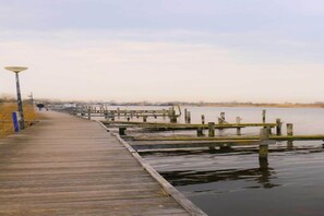 A wooden boardwalk extending into a body of water with a lamp post on the left. - Modern chalet near Lake Sneek (Terkaple)