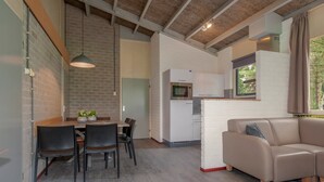 Un intérieur moderne comprenant un coin repas, une cuisine et un canapé.