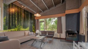 Un salon moderne avec un canapé, des fauteuils, une table et une cheminée.