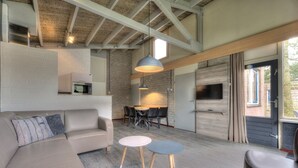 A modern living room with a sectional sofa, a dining table, and a TV.
