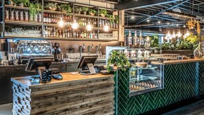 Un espace bar doté d’un comptoir en bois, de plusieurs robinets et d’étagères remplies de bouteilles et de verres.