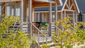 A row of wooden cabins with large windows and a covered outdoor area.