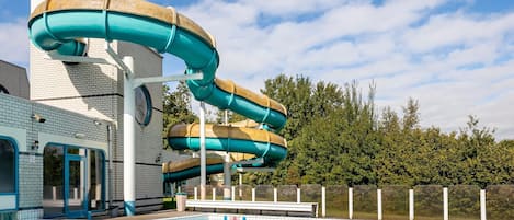 Un parque acuático con una piscina grande y una estructura con toboganes.