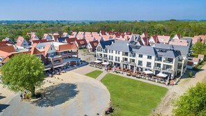 Een groot hotel met meerdere gebouwen, een centrale binnenplaats en een strandgedeelte.