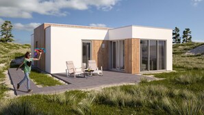 Een modern huis met een terras, twee stoelen en een tafel.
