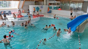 An indoor swimming pool with multiple lanes, a slide, and a lifeguard stand. - Holiday Home near Breda & De Biesbosch Park (Oosterhout)