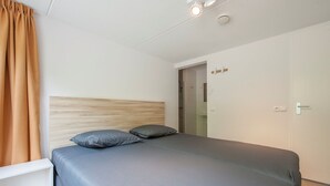 Un dormitorio moderno con cama, mesita de noche y armario.