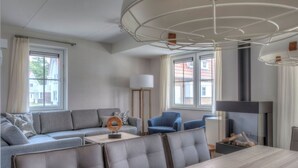 Una sala moderna con sofá, sillas, una mesa de comedor y una chimenea.
