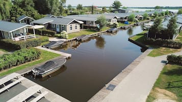 Een woongebied aan een kanaal, met huizen, een steiger en een boot.