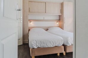 Une chambre à coucher avec un lit, une tête de lit en bois et un éclairage intégré.