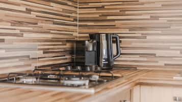 Cocina con diseño moderno, que incluye una estufa a gas y una cafetera.
