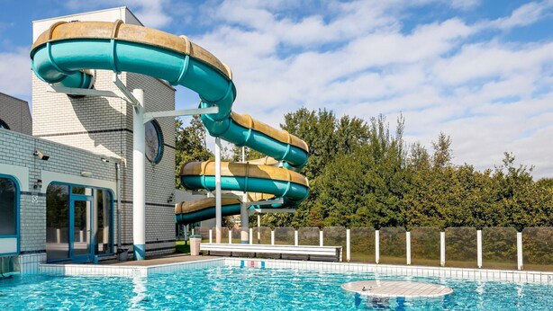 A water park with a large water slide and a swimming pool. - Forest Glamping near Emmen (Borger)