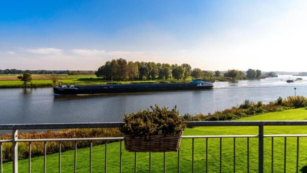 A river with a boat, a grassy area, and trees in the background.