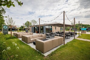 Relax in comfort on the patio, surrounded by lush greenery and a stylish seating area.