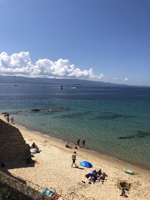 A beach with clear water, a lighthouse in the distance, and people relaxing on the sand. - Spacious, comfortable 90 m2 T3 apartment in downtown Ajaccio (Ajaccio)