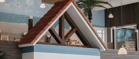 A model house with a sloped roof, wooden beams, and a striped facade.