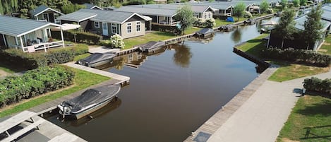A canal-side residential area with houses, a dock, and a boat.