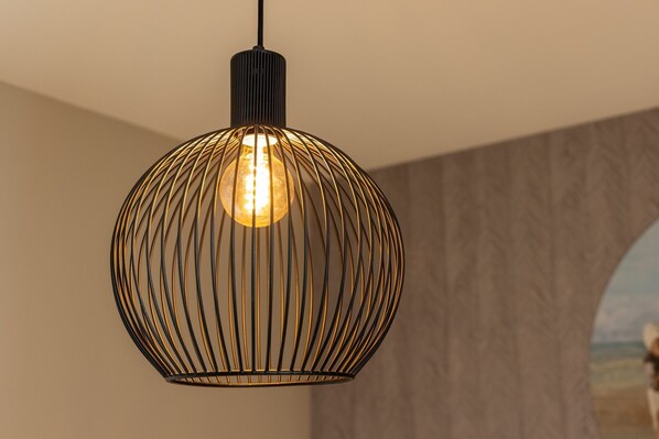 A pendant light with a spherical design and a visible bulb.