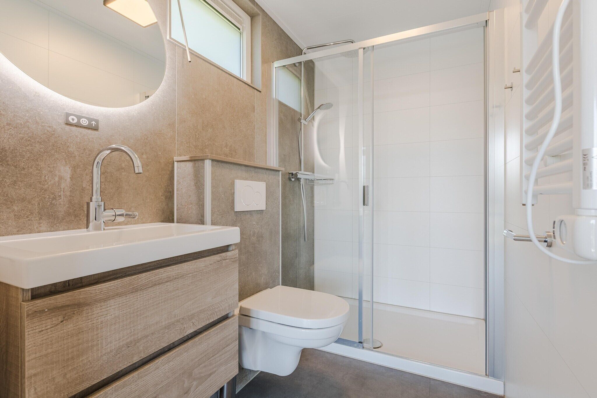Un baño con lavamanos, inodoro y cabina de ducha de vidrio.