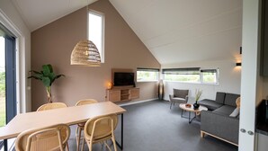 Un salon moderne comprenant un coin repas, un canapé et un téléviseur.