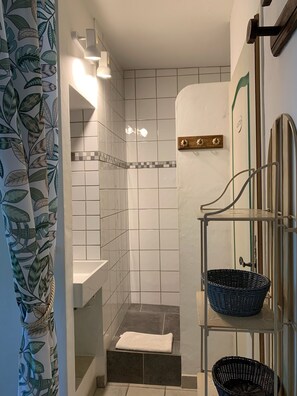 Een douche, handdoeken, zeep, toiletpapier