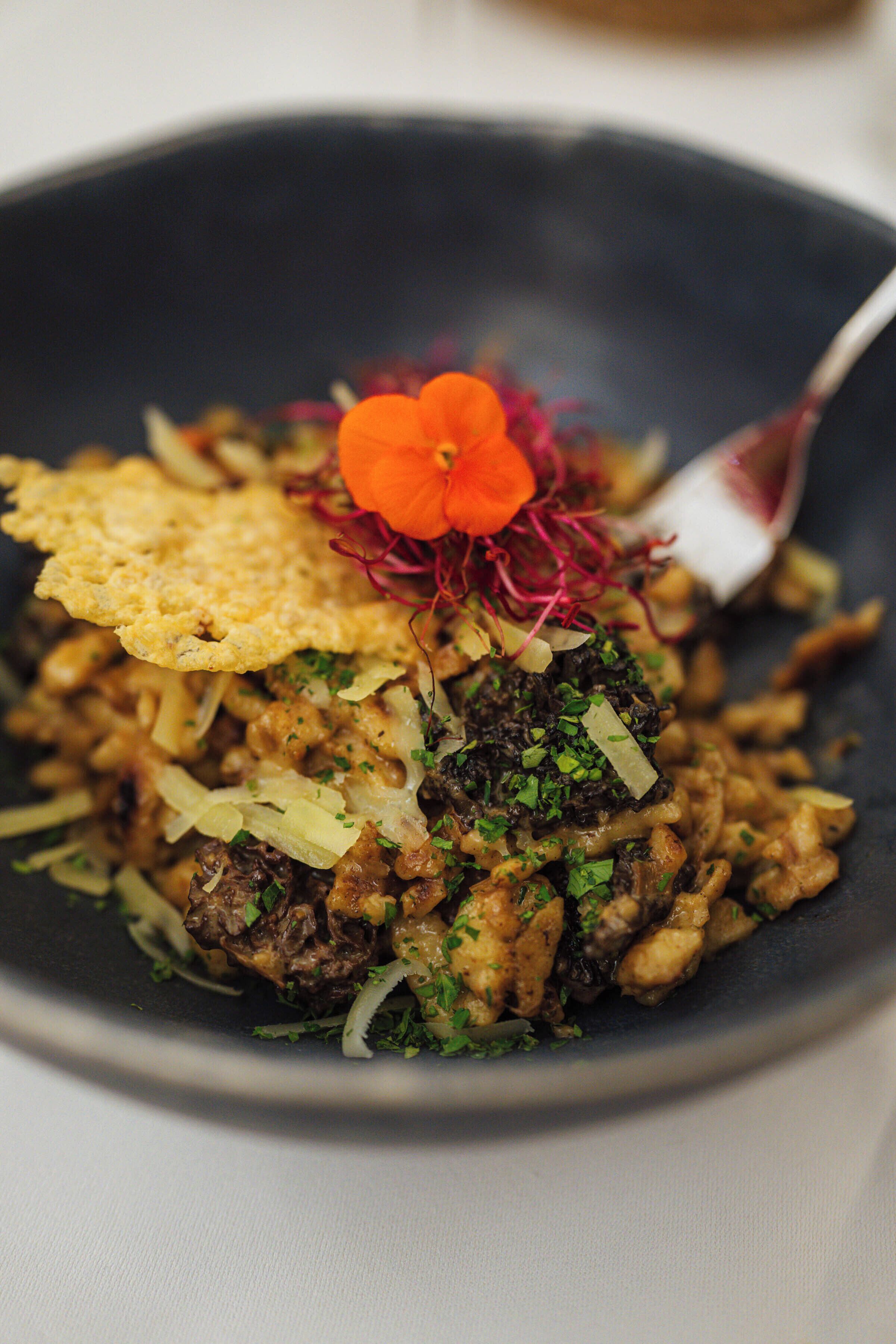 A bowl of food with a flower garnish.