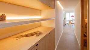 A modern kitchen with wooden shelves and a countertop. - Stylish Apartment in Palamós - Near Sea with Parking (Palamós)