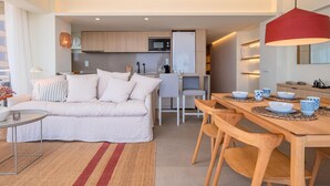 A modern apartment with a living room, dining area, and kitchen. - Stylish Apartment in Palamós - Near Sea with Parking (Palamós)