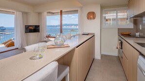 A modern kitchen with a large window overlooking a marina and cityscape. - Stylish Apartment in Palamós - Near Sea with Parking (Palamós)