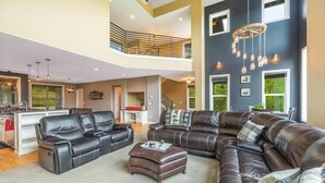 A spacious living area with a large sectional sofa, a dining area, and a kitchen. - Private chalet on golf course 5 min to Silver mntn (Kellogg)