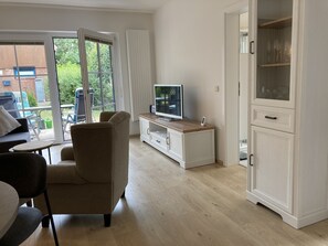 Un salon moderne avec un téléviseur, un meuble et un canapé.