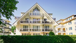 A multi-story hotel with balconies, large windows, and a clear sky. - Die Ferienwohnung Austernperle im Haus am Kurpark in Baabe (Baabe)